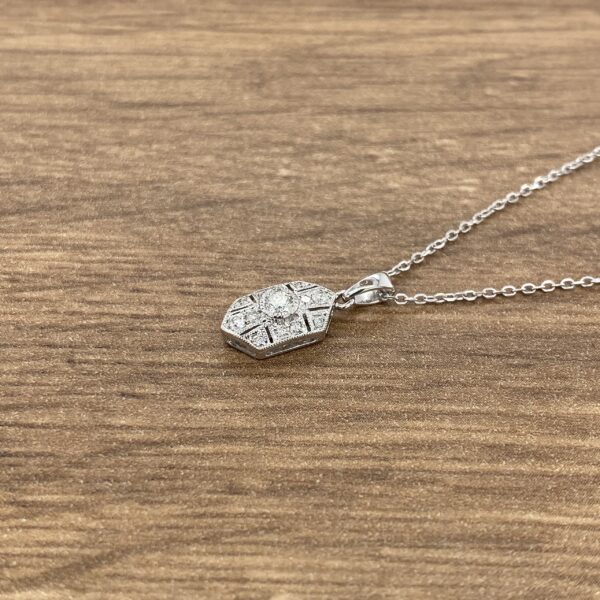 Diamond pendant necklace on wood background.