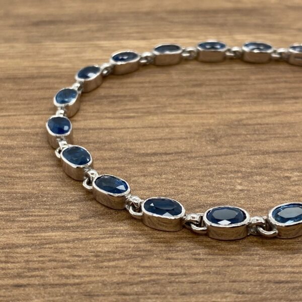 A sterling silver bracelet with blue sapphire stones.