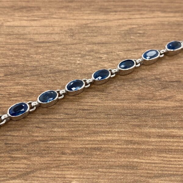 A sterling silver bracelet with blue sapphire stones.