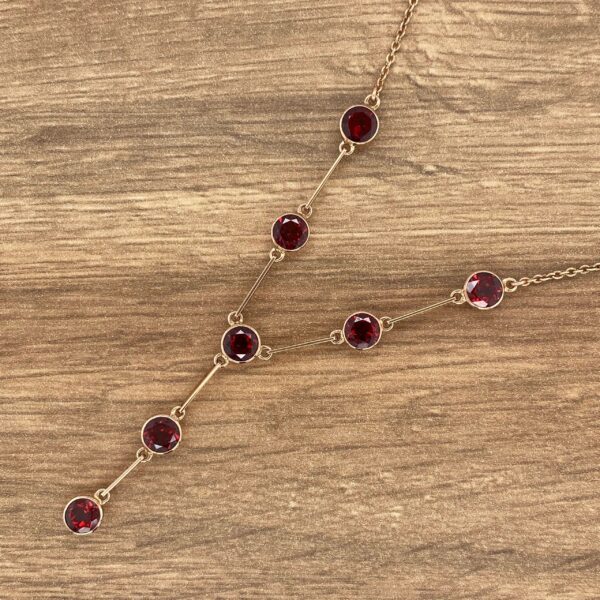 Gold necklace with red gemstones.
