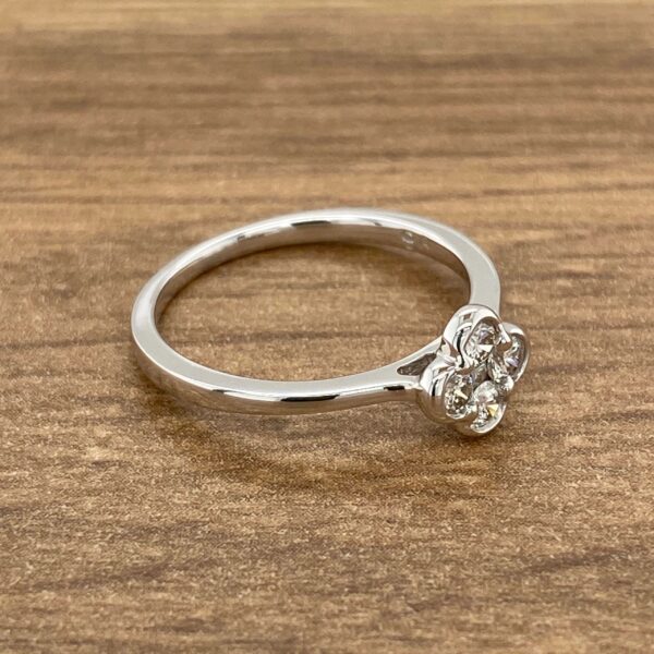 Diamond cluster ring on wooden background.