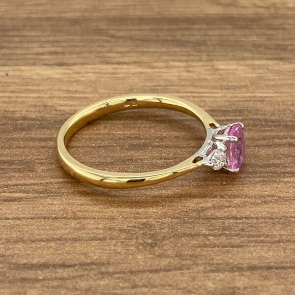 Gold ring with pink sapphire and diamonds.