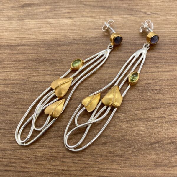 Silver and gold earrings with green stones.