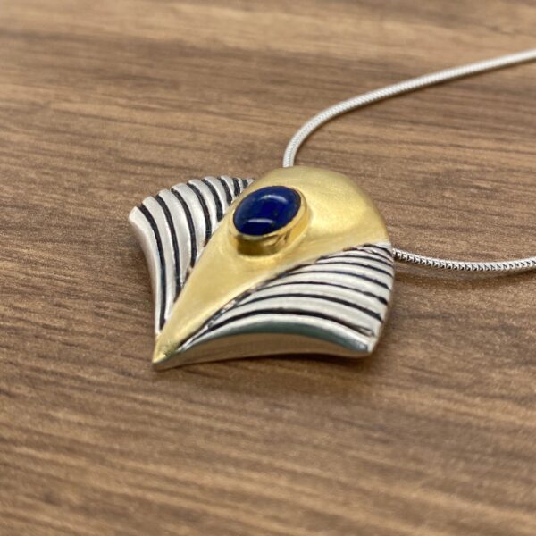 Gold and silver pendant with blue stone.