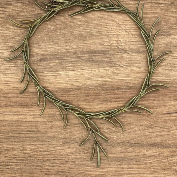 Gold rosemary wreath on wood background.