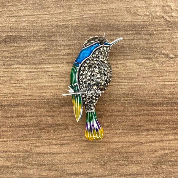 Silver bird brooch with green and blue enamel.