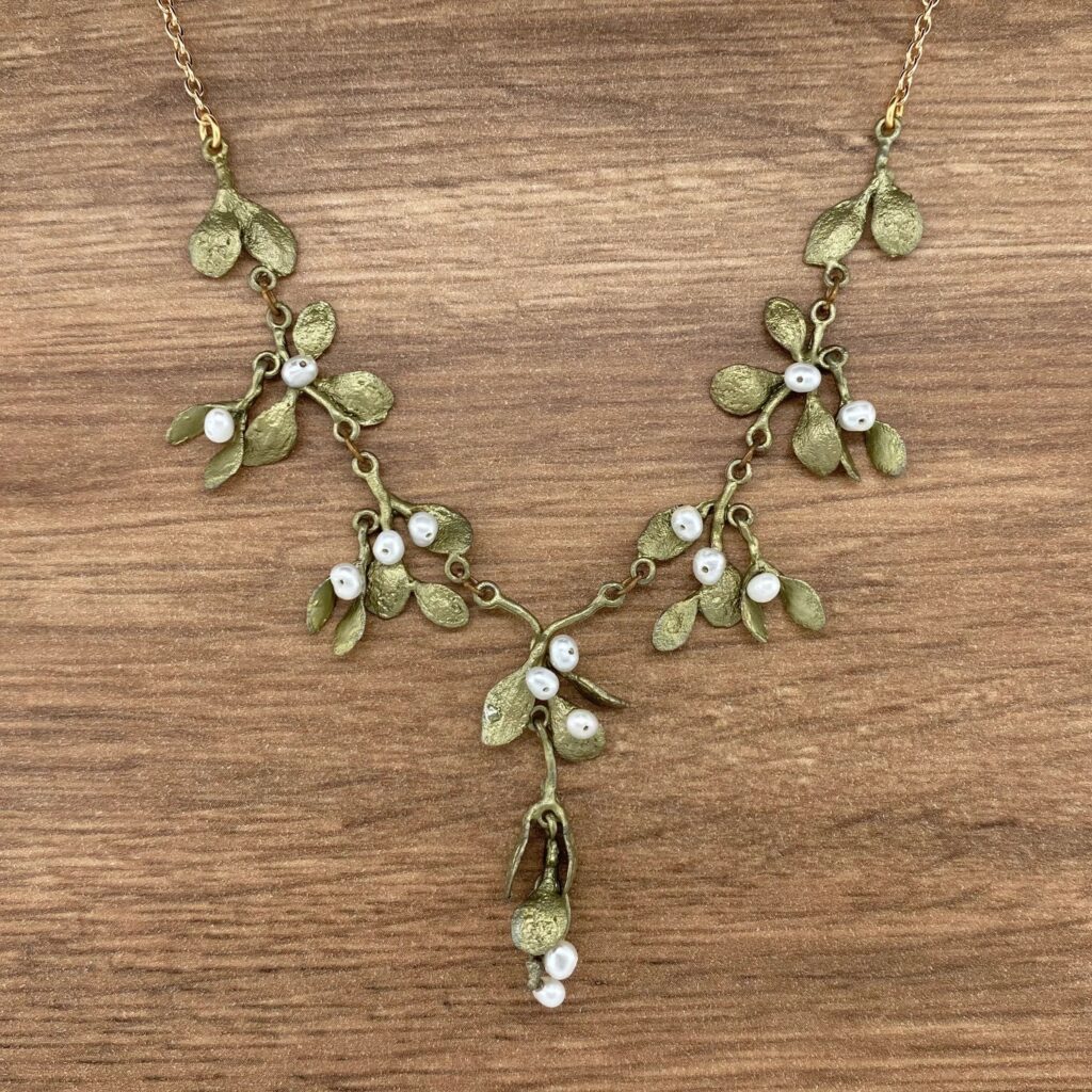 Gold mistletoe necklace with white pearls.