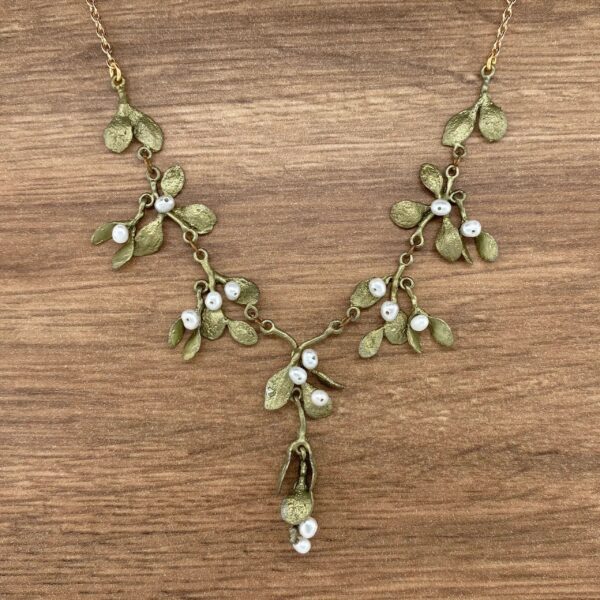Gold mistletoe necklace with white pearls.