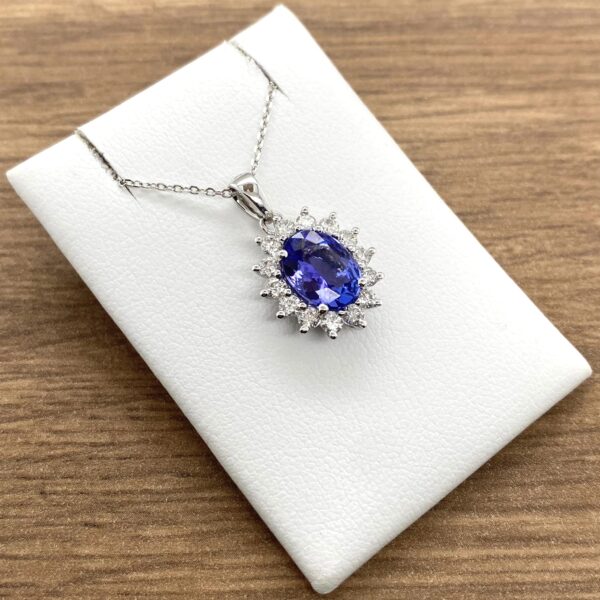 Oval sapphire and diamond pendant necklace.