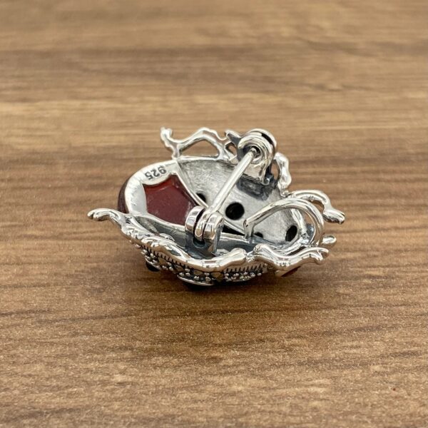 Silver ladybug brooch with red stone.