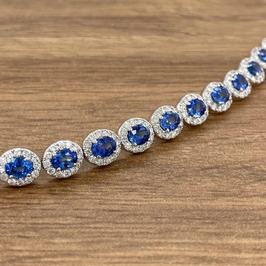 A blue sapphire and diamond bracelet on a wooden table.