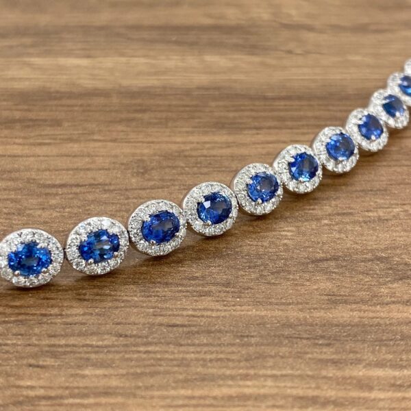 A blue sapphire and diamond bracelet on a wooden table.