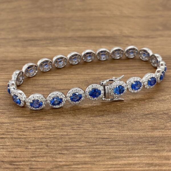 A blue sapphire and diamond bracelet on a wooden table.