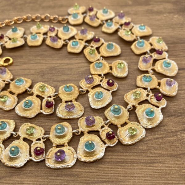 Gold necklace with multi-colored gemstones.