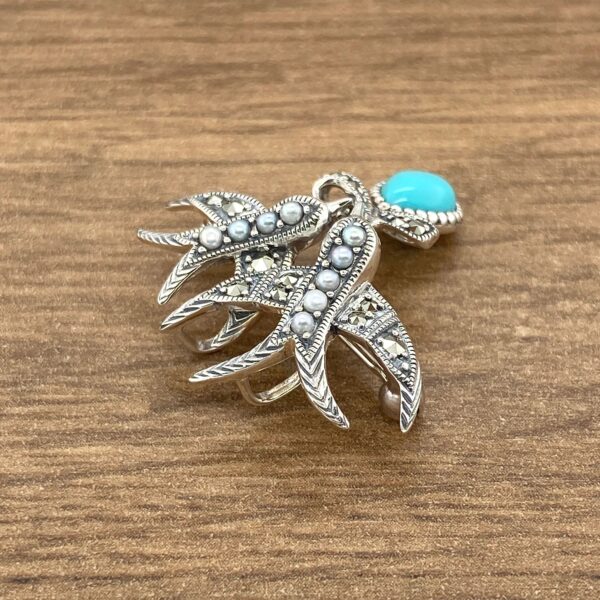 Silver brooch with turquoise and pearls.