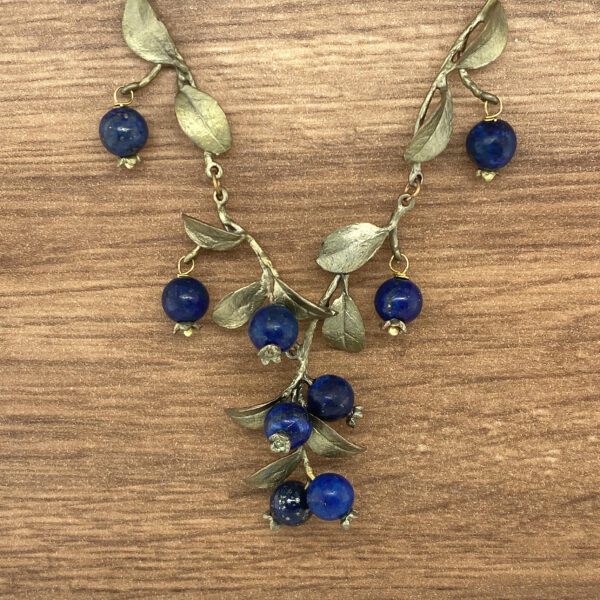 Silver leaf necklace with blue gemstone berries.