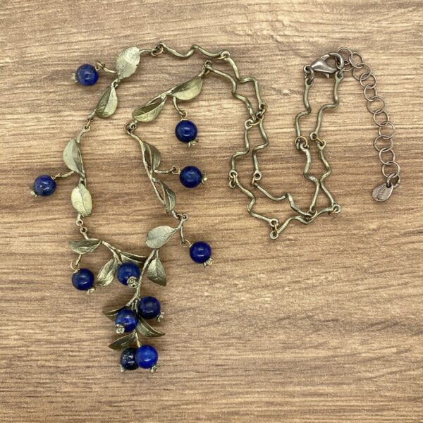 Silver necklace with blue berry charms.