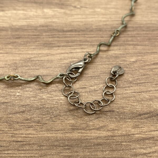 Silver chain necklace clasp detail.