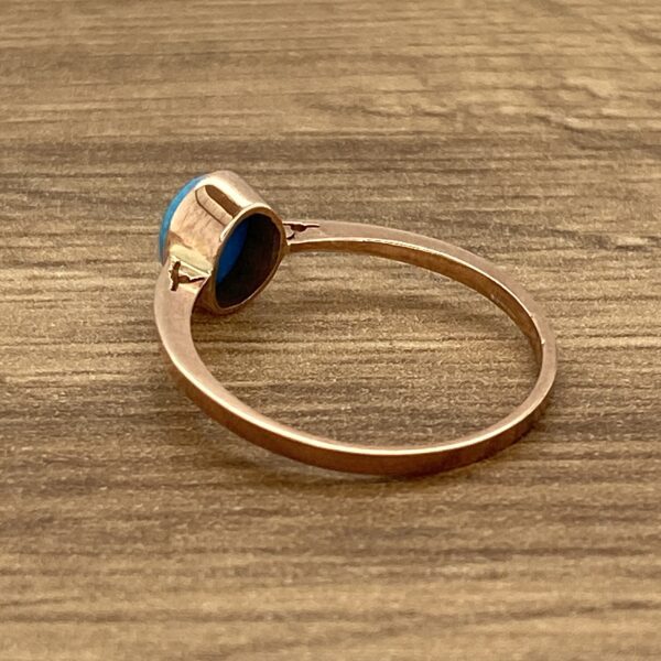 Gold ring with a blue gemstone.