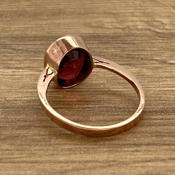 Gold ring with a red gemstone.