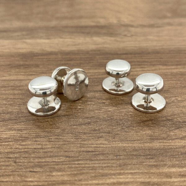 Three silver shirt collar stays.