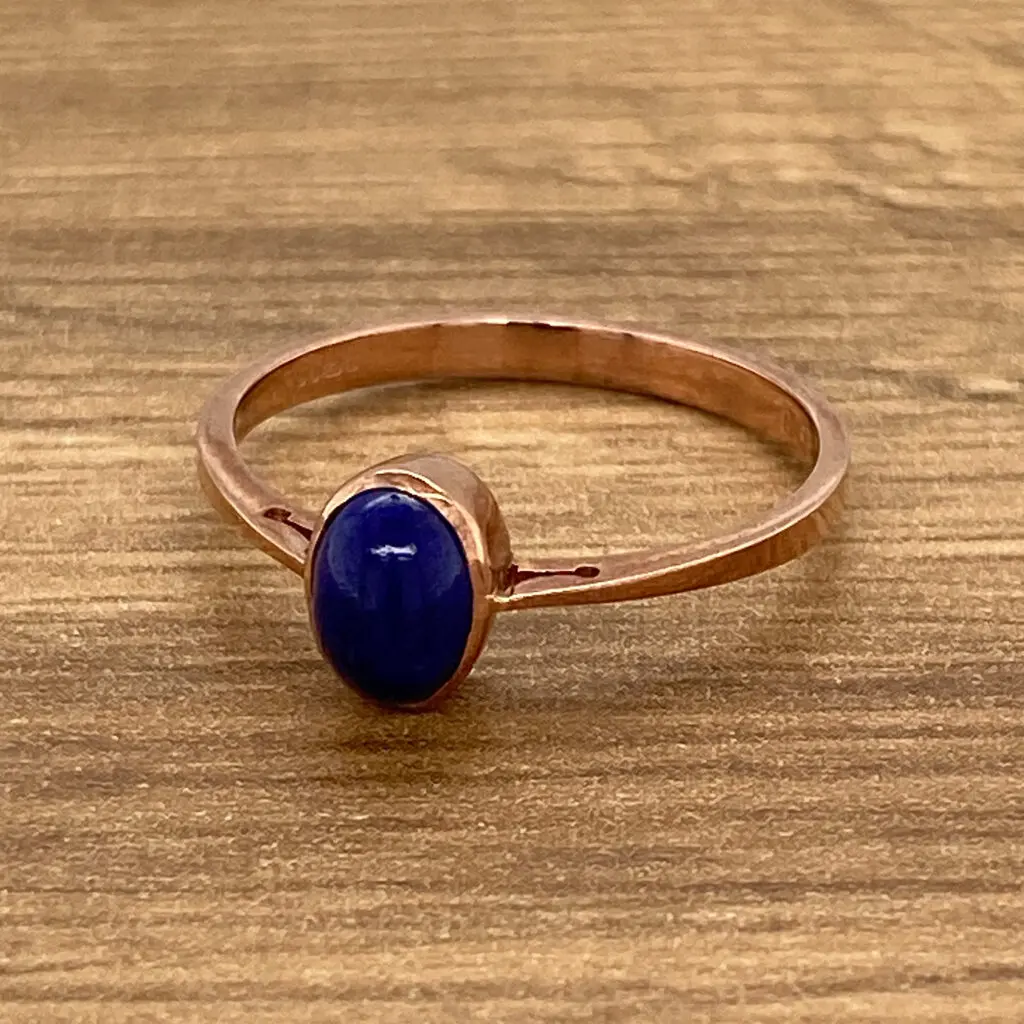 Rose gold ring with blue gemstone.