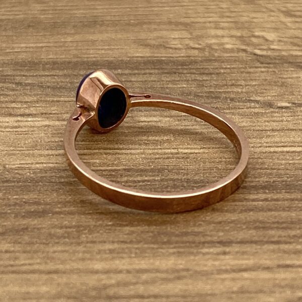 Rose gold ring with blue oval stone.