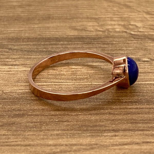 Rose gold ring with blue gemstone.