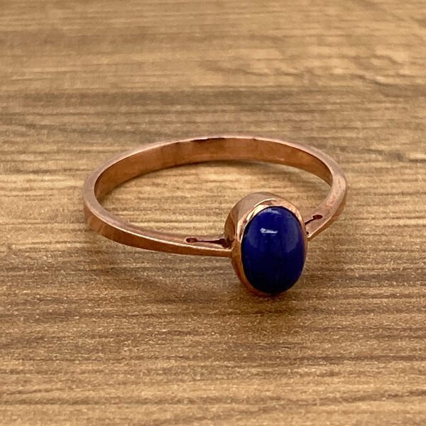 Rose gold ring with a blue gemstone.