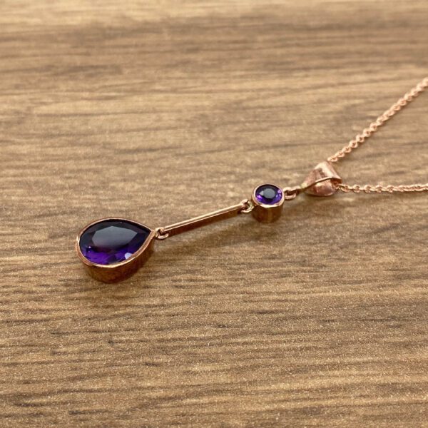 Rose gold necklace with purple amethysts.