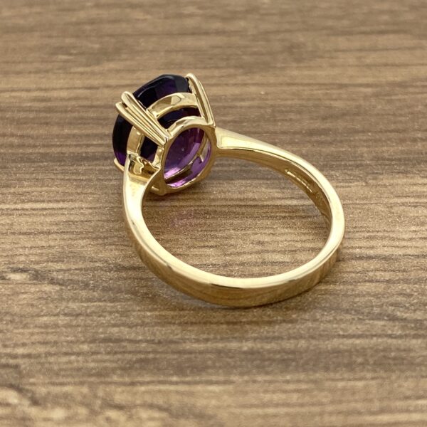 Gold ring with a large purple gemstone.