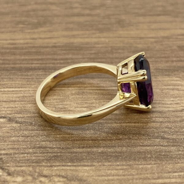 Gold ring with a large purple gemstone.