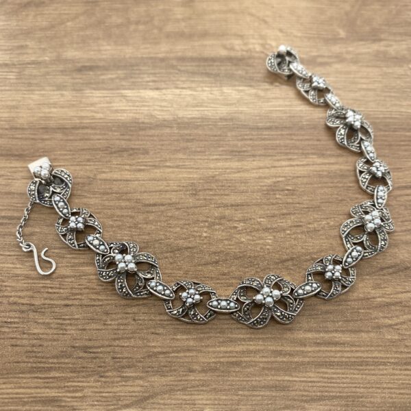 Silver bracelet with pearl and marcasite accents.