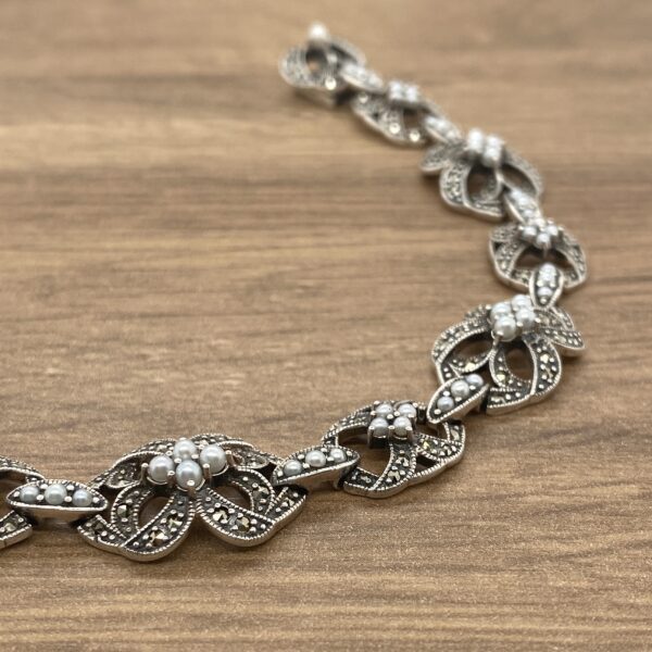 Silver bracelet with pearl and marcasite accents.