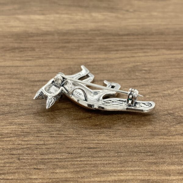 A Silver & Marcasite Enamel Fox Brooch on a wooden table.