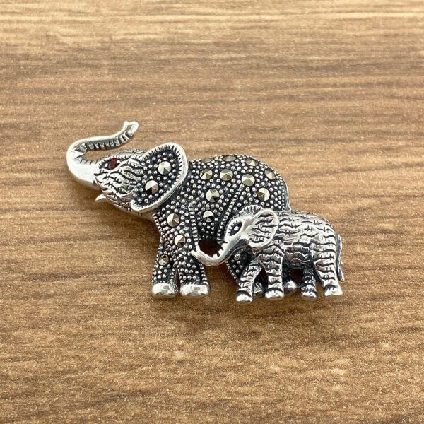 Silver elephant brooch with baby elephant.