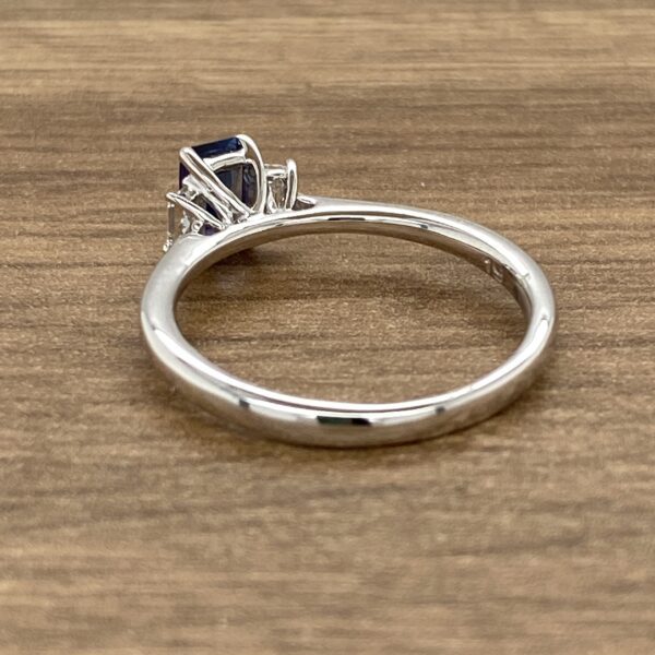 Silver ring with blue gemstone and diamonds.