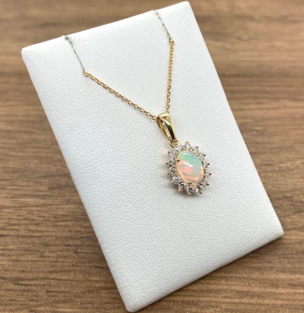 An opal and diamond pendant on a white background.