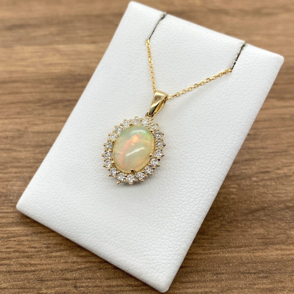 Gold opal pendant with diamond halo.