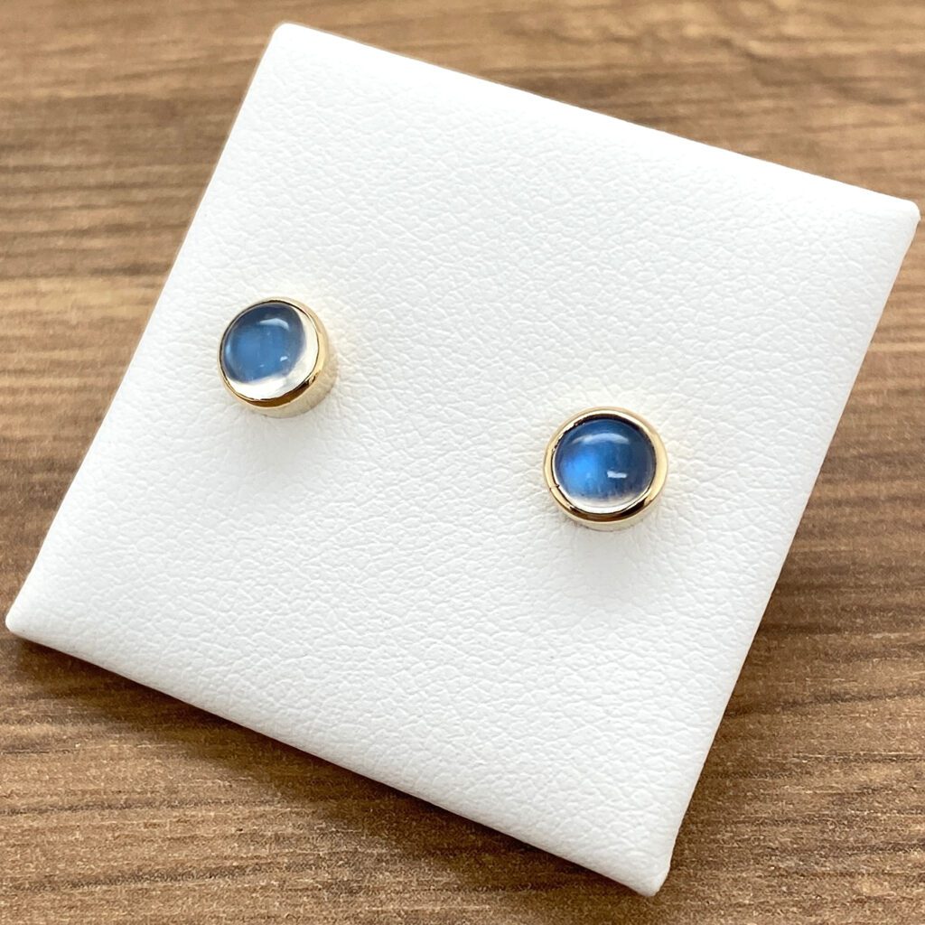 Gold stud earrings with blue gemstones.