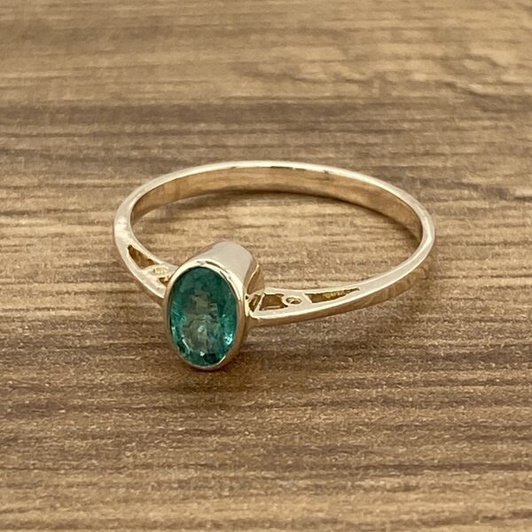 Gold ring with a green gemstone.