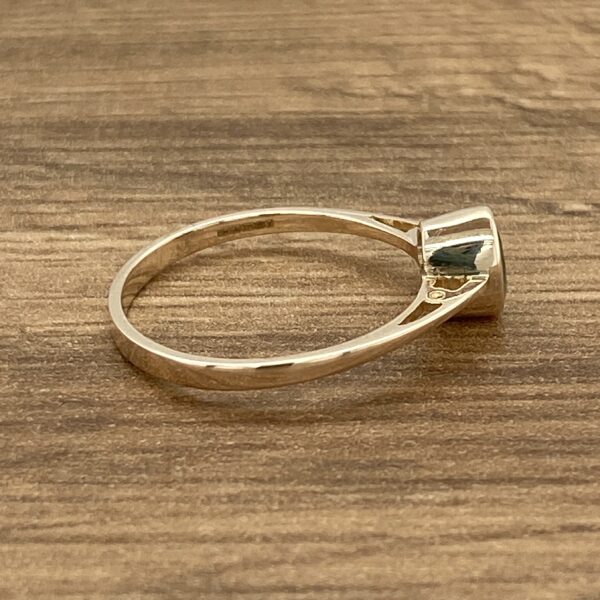 Gold ring with a green gemstone.