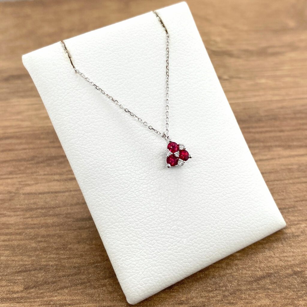 Ruby and diamond pendant necklace on display.