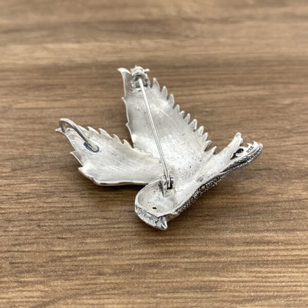 Silver bird brooch with marcasite accents.