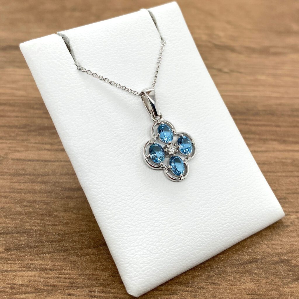 Silver necklace with blue topaz flower pendant.