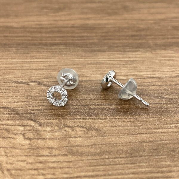 Diamond circle stud earrings on wood.
