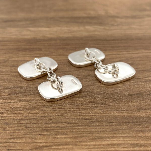 Silver cufflinks with chain connection.