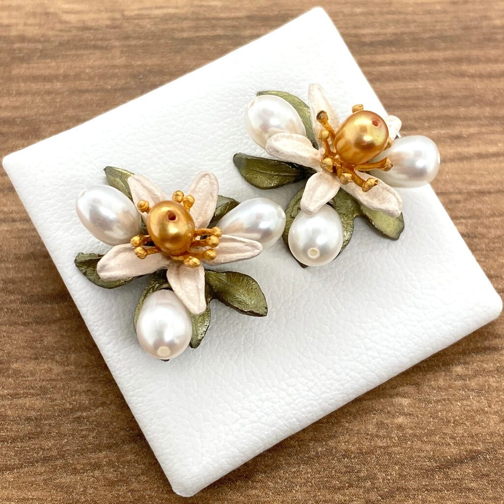White flower pearl earrings on display.
