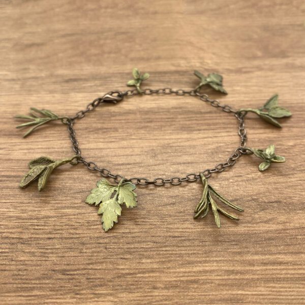 Metal bracelet with green leaf charms.
