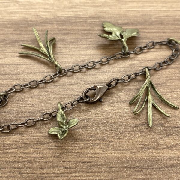 Metal bracelet with green leaf charms.